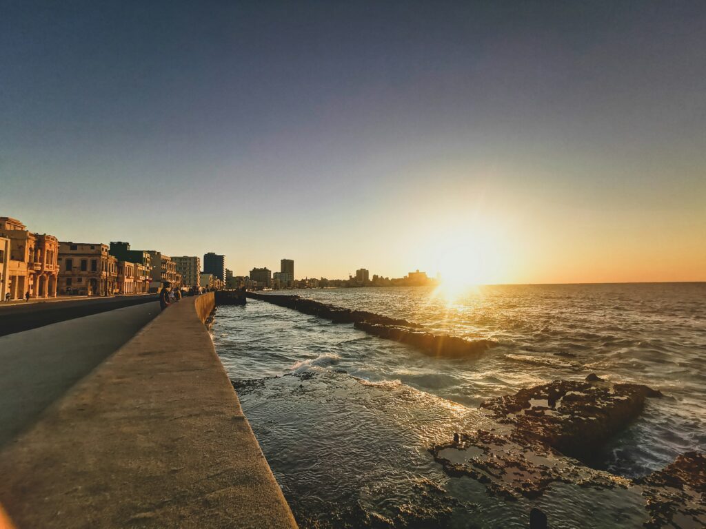 Puesta de sol en el Malecón de La Habana. Visa a edificios y el mar.