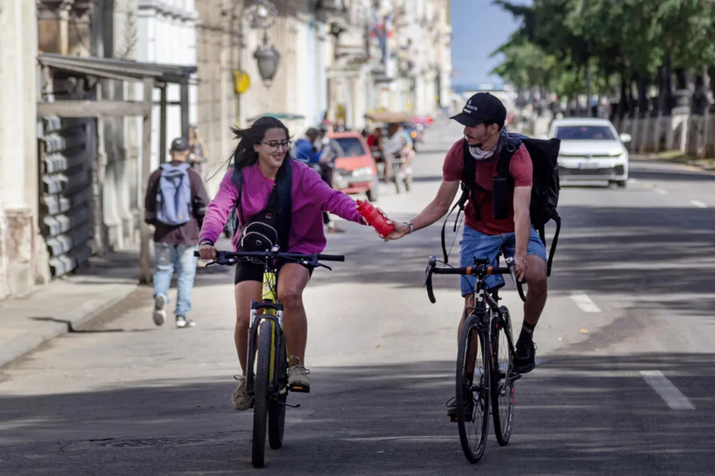 Dos ciclistas compartiendo su botella de agua en Paseo del Prado